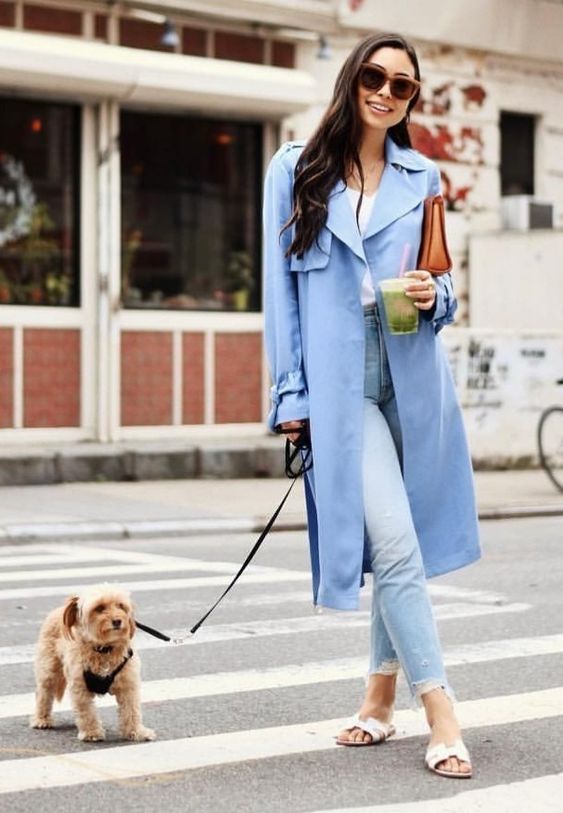 a blue trench, light blue ripped jeans, white slippers and a white tee plus a clutch