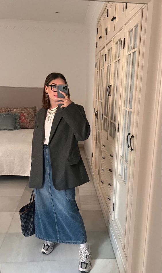 a chic outfit with a white tee, an oversized grey blazer, a blue denim maxi, neutral trainers and a black checked tote for spring