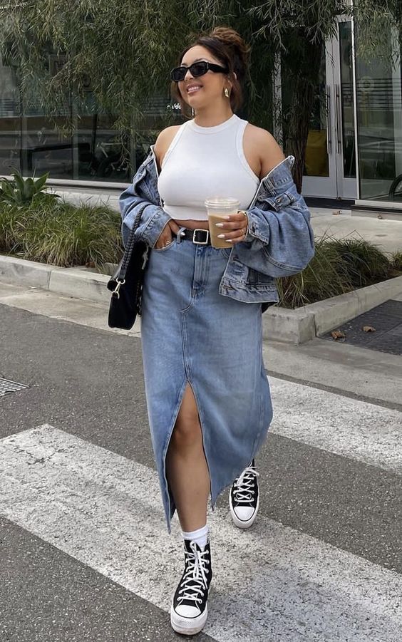 a double denim look with a white crop top, a blue denim jacket and a matching midi skirt, black high top sneakers and a black bag