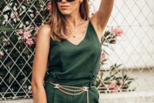 a green jumpsuit, a copper chain belt, a wicker bag and floral sneakers for a spring to summer look