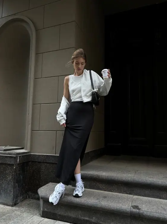 a lolvely black and white look with sleeveless top, a black maxi skirt, a white cropped jacket, white trainers and socks and a black baguette bag