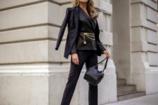 a refined look with a black pantsuit, a gold chain belt, a second blazer, a black bag and mules for a special occasion