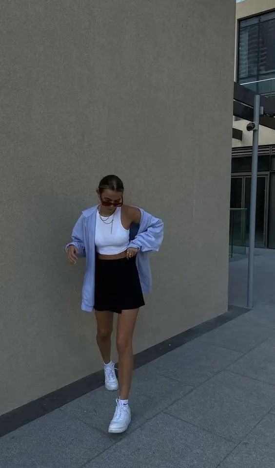 a summer look with a white crop top, a black mini, a blue oversized blazer, white sneakers and socks