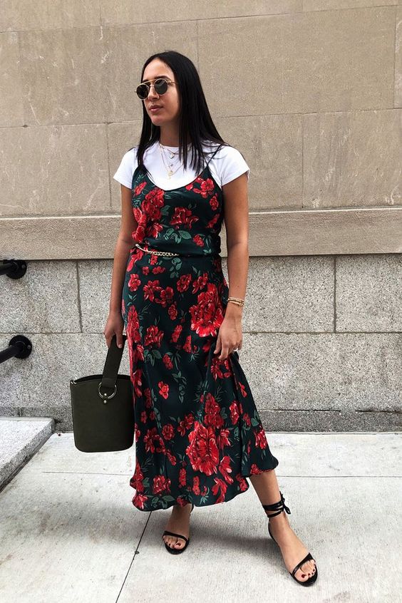 a summer outfit with a white tee, a dark floral slip midi dress, black lace up shoes, a black bucket bag and a gold chain belt