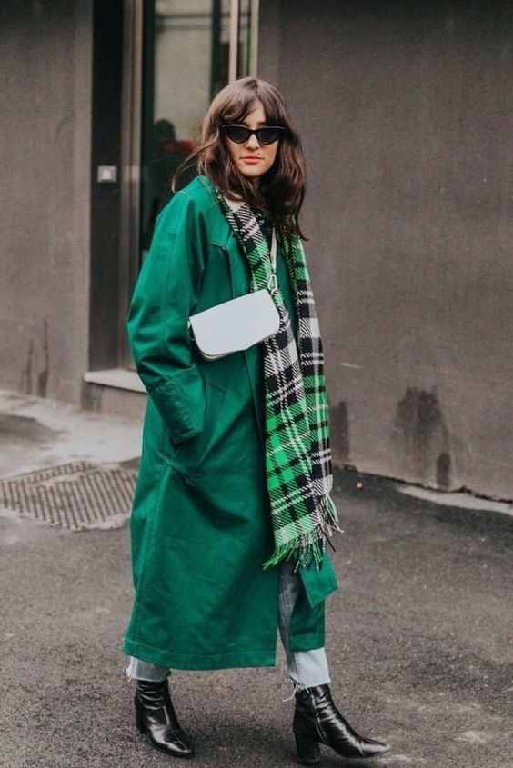 an emerald trench, light-colroed jeans, blakc booties, a checked scarf and a white bag for a bold look