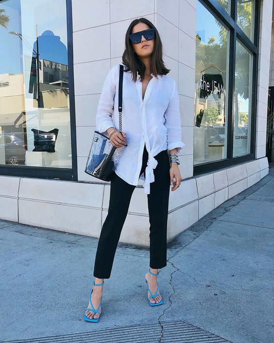 black straight jeans, a white oversized shirt, a clear bag and bold blue square toe heels