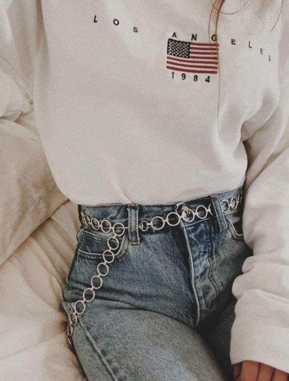 blue high waisted jeans, a white sweatshirt and a silver circle chain belt for an accent