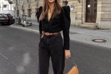 11 a statement and fashionable look with a black blouse with catchy shoulders, black slouchy jeans, brown booties and a hat plus a saddle bag