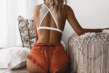 13 a white lace crop top with a criss-cross back and rust-colored ruffle mini shorts are a bold combo