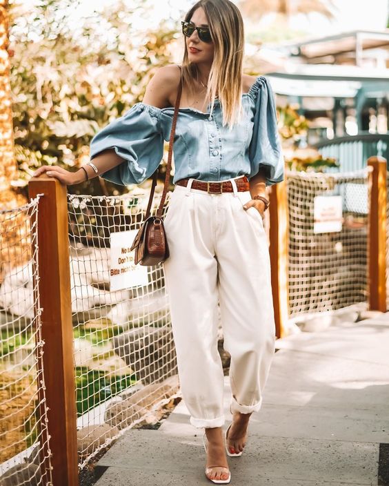 a chic summer look with white slouchy pants, a chambray off the shoulder top, acrylic shoes and a brown bag