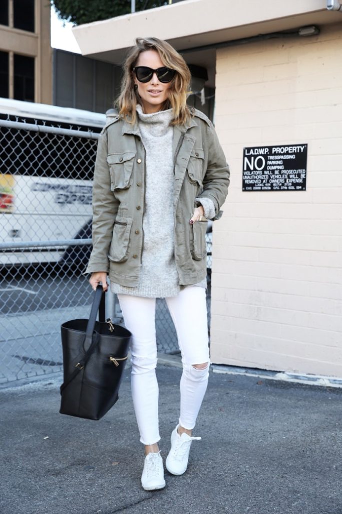 a winter outfit with an oversized grey sweater, white skinnies, white skinnies, a green cargo jacket and a black bag