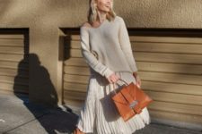With white one shoulder sweater, brown suede boots and brown bag