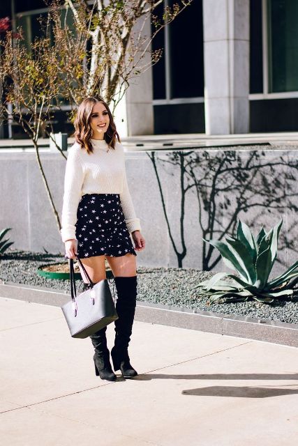 With white sweater, black tote bag and black over the knee boots