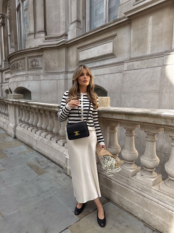 a French chic spring look with a striped cardigan, a neutral maxi skirt, black flats, a black bag is amazing