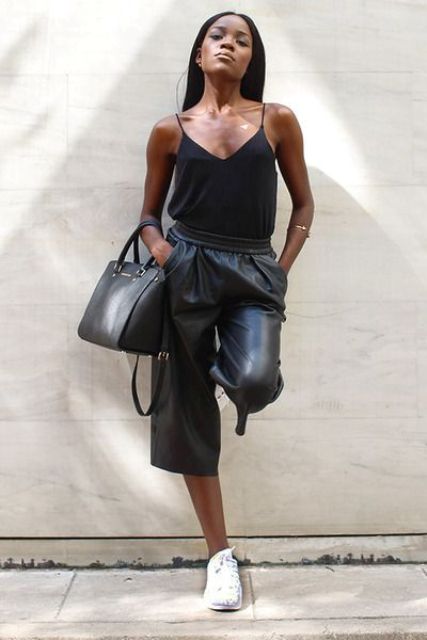 a black strap top, black leather bermuda shorts, white trainers and a black bag for a casual look