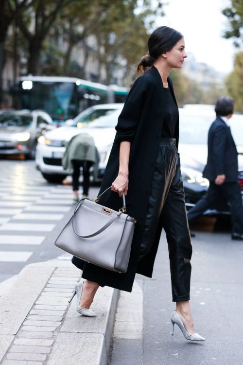 a business look with a black top, lack leather cropped pants, silver shoes, a black coat and a grey bag