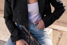 a casual look with high waisted blue jeans, a white top, a black cropped blazer and a printed clutch
