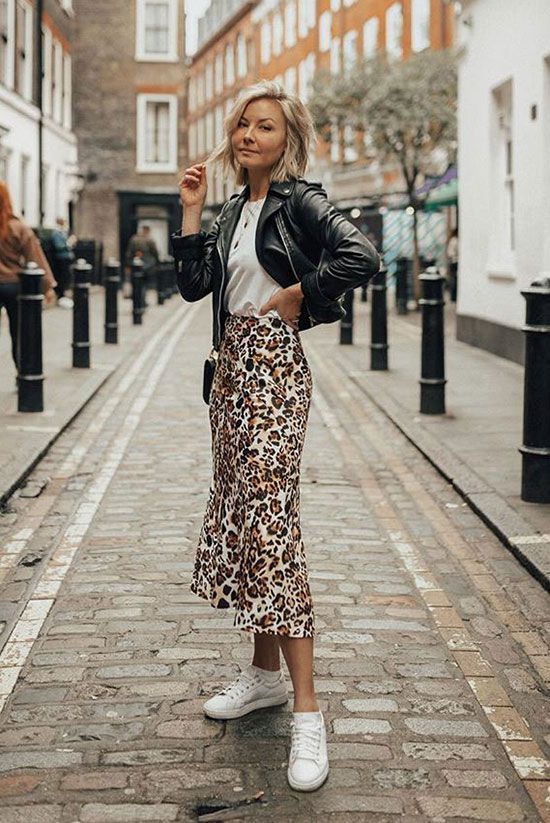 a casual spring outfit with a white tee, an animal print slip skirt, a black leather jacket and white sneakers