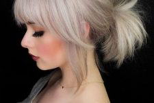 a low bleached blonde ponytail with a bump on top and classic and side bangs is a super cool idea