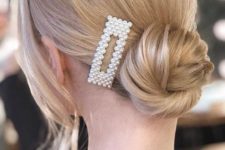 a low bun accented with a rectangle pearl hair clip is a cool trendy idea to rock