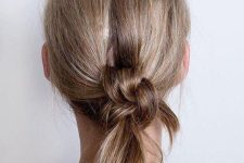 a messy braids knot updo with a bit of volume on top is a chic and cool idea to rock, you can make it with medium or long hair
