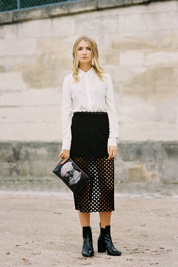 a monochromatic look with a white shirt, a black mini skirt, a black perforated skirt, black boots and a clutch