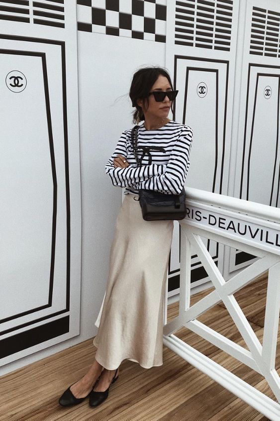 a pretty monochromatic look with a striped long sleeve top, a neutral satin skirt, black flats, a black bag is Parisian chic