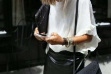 a statement monochromatic work look with an oversized white tee, a black leather asymmetrical mini, a black bag