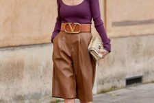 a statement outfit with a purple cutout top, a statement necklace, brown bermudas, brown shoes and a clutch