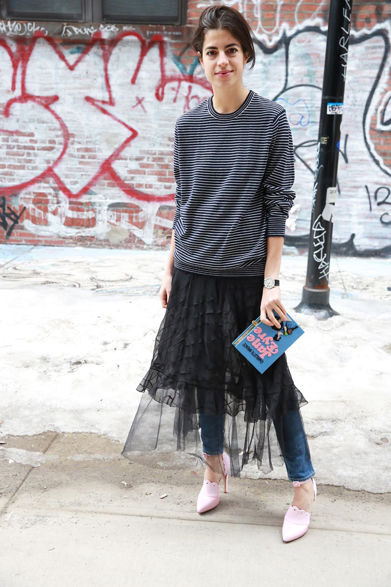 A striped long sleeve top, blue jeans, a black sheer lace skirt, pink shoes and a quirky clutch