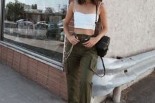 a summer look with green cargo pants, white sneakers and a crop top and a black backpack