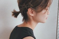 a super short low ponytail with side bangs and bobby pins for an accent is a cool and catchy idea