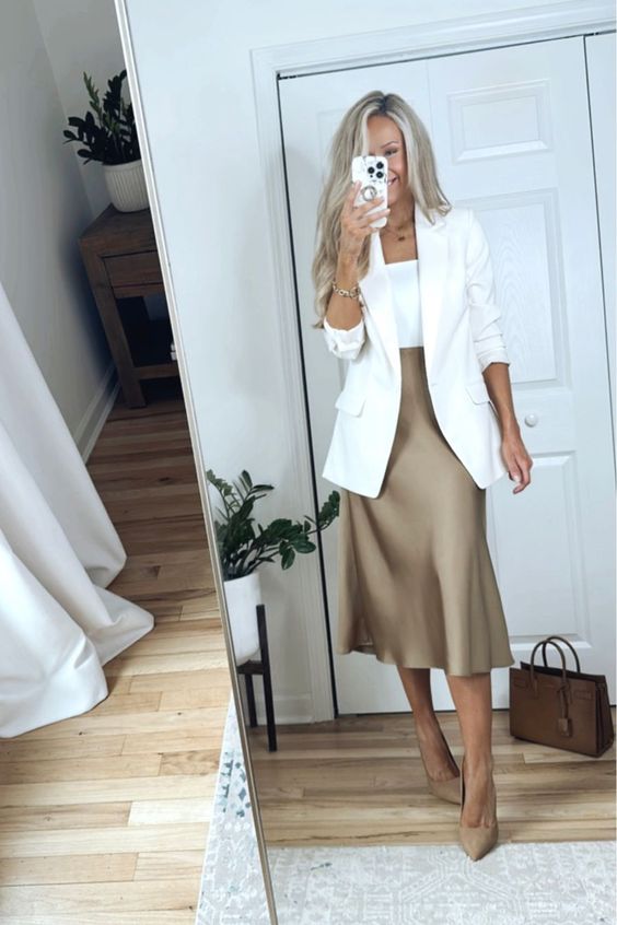a timeless spring outfit with a white top, blazer, a tan satin midi skirt, matching shoes and a brown bag