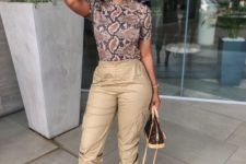 a trendy outfit with a snakeskin top, tan cargo pants, blush shoes and a comfy bag