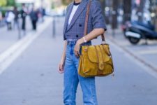 a trendy spring look with a white tee, a cropped blazer, blue jeans, navy booties and a mustard bag