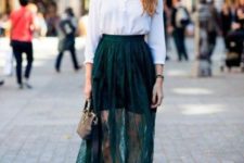 a white long sleeve top, a green mini plus a sheer lace green maxi skirt, white sneakers and a black clutch