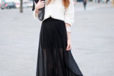 a white oversized top, a black mini skirt, a black sheer pleated overskirt, black booties and a clutch
