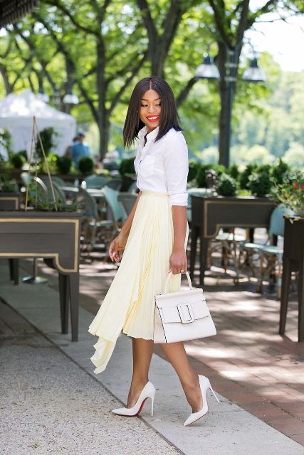 a white shirt, a light yellow pleated asymmetrical midi skirt, white heels and a white bag for work