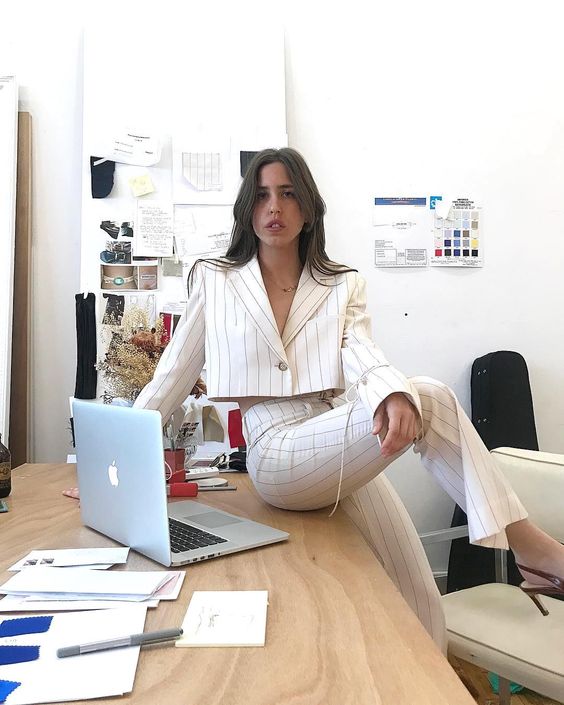 a white striped pantsuit with a cropped blazer and heels for a bold statement work look