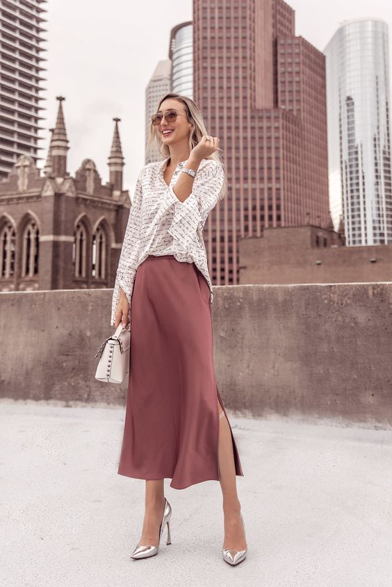 a work outfit with a striped shirt, a mauve slip skirt, silver heels and a white bag for spring