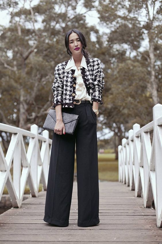 a work outfit with a white blouse, a cropped tweed blazer, black palazzo pants and a clutch