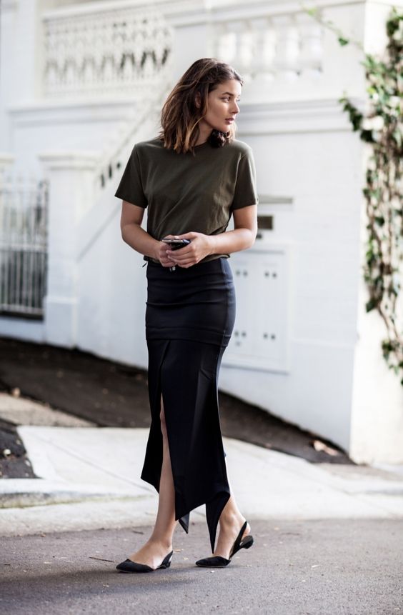 an olive green tee, a black asymmetrical midi pencil skirt, black flats for a summer work look