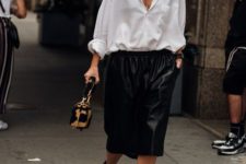 an oversized white shirt, oversized black bermuda shorts, black strappy heels and a printed bag