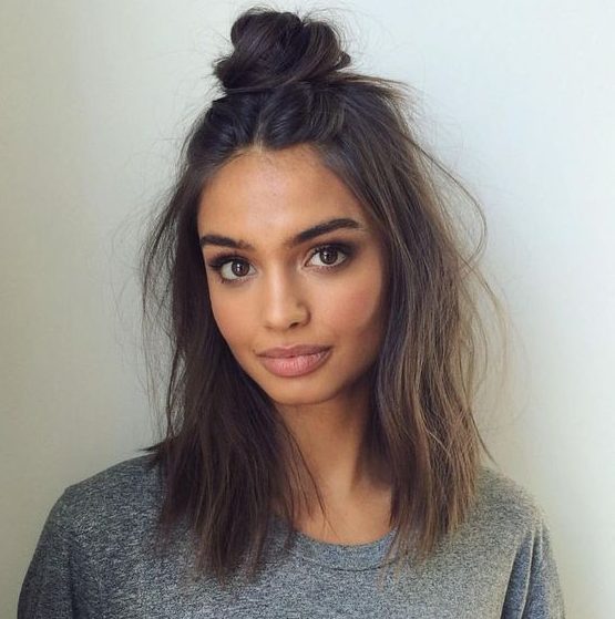 textural hair down and a top knot is a simple and casual hairstyle for medium length hair