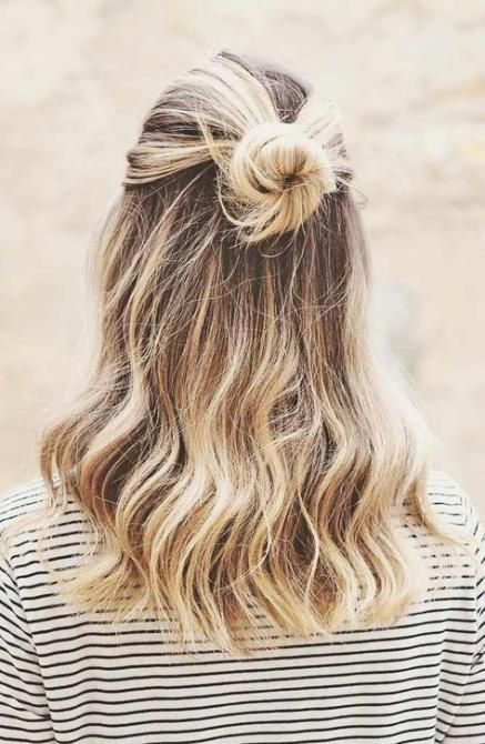 a simple half updo with a bun and waves down is a cool idea for both medium and long hair