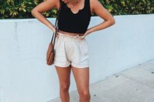 With black crop top, brown bag and white sneakers