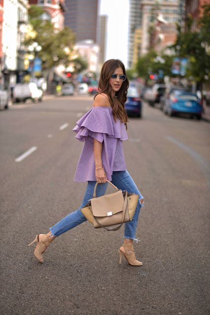 With distressed skinny jeans, beige bag and beige high heels
