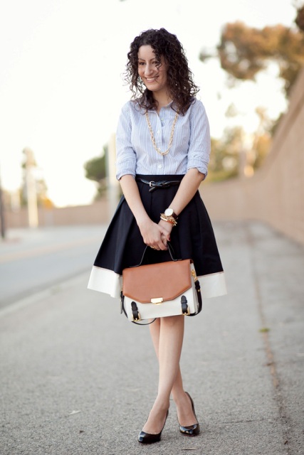 With striped shirt, black pumps and white, brown and black bag