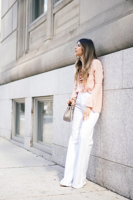 With white flare pants, high heels and gray bag
