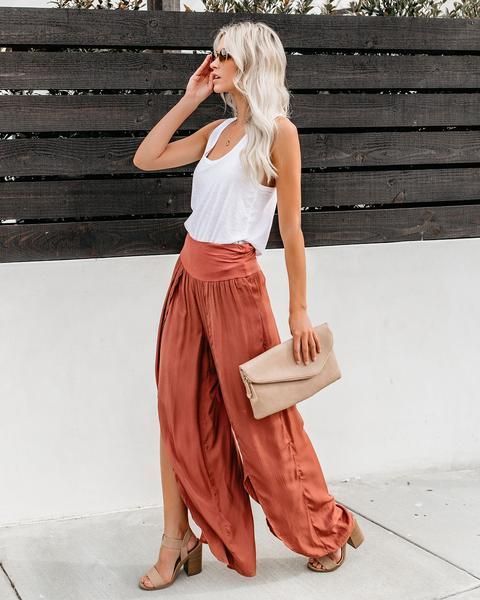 With white top, beige clutch and beige sandals